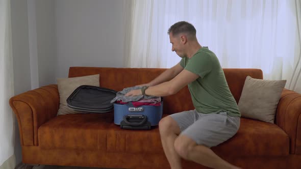 A Man Packs Things in a Suitcase Quickly Hurrying