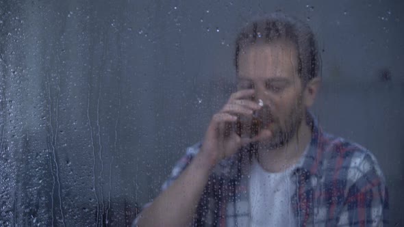 Happy Man Drinking Brandy Alone on Rainy Day, Celebrating Career Promotion alt