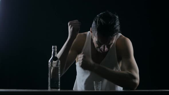 Depressed Man Crying with a Bottle of Vodka
