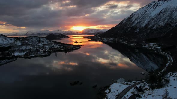 Amazing Aerial timelapse of beautiful snow covered mountains withing clouds at sunset mirrored in th alt