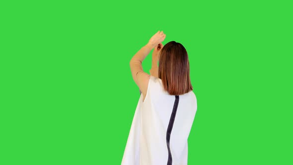 Android Girl Stands Operating Virtual Monitors on a Green Screen Chroma Key