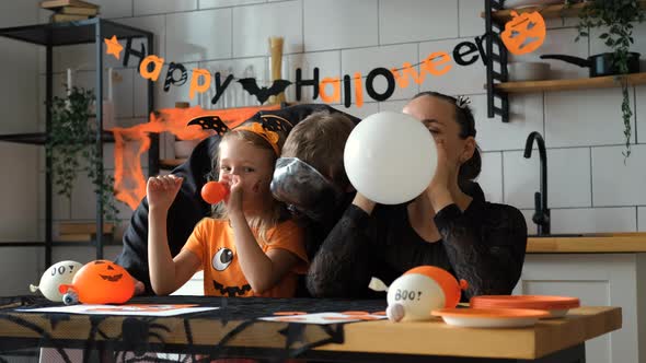 Family in Halloween Costumes Inflating Balloons alt