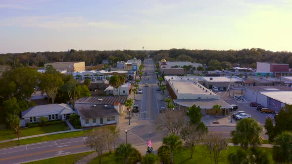 Flying Over Trees and Towards the Main Road of a Small Town in Florida alt