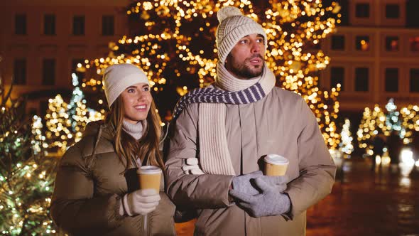 Couple with Coffee Talking in City on Christmas
