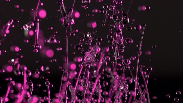 Super Slow Motion Shot of Splashing Oily Violet Liquid Isolated on Black Background at 1000Fps. alt