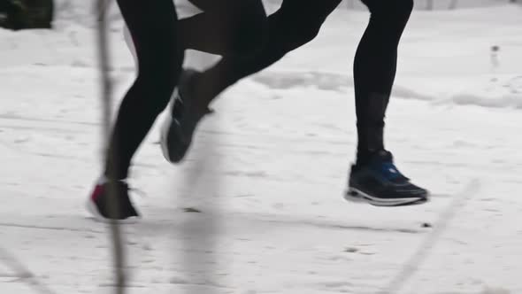 Athletes Running Down Snow Trail alt