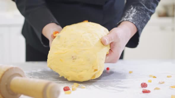 Women Kneads Dough with Candied Fruits for Easter Cakes alt