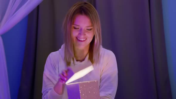 Beautiful Blonde Young Woman Opening Surprise Gift Box with Light Inside RED 8K alt