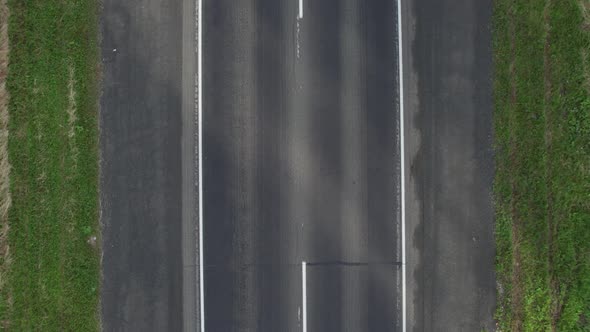 Aerial View of Scenic Road Between Green Trees with Pines on a Sunny Summer Morning alt
