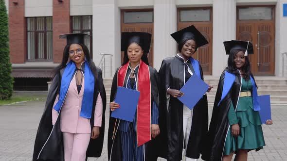 Happy Graduates of a University or College of African American Nationality with Blue Diplomas in alt