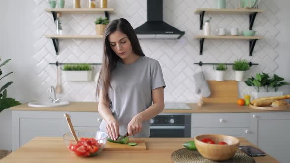 Happy Girl Cutting Vegetables in Kitchen