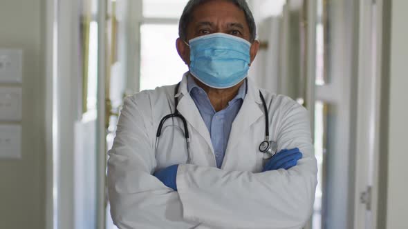 Portrait of senior mixed race male doctor wearing face mask alt
