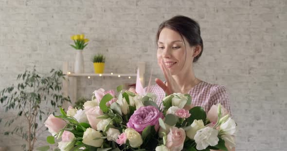 Young Girl with Closed Eyes Receives Bouquet of Flowers alt