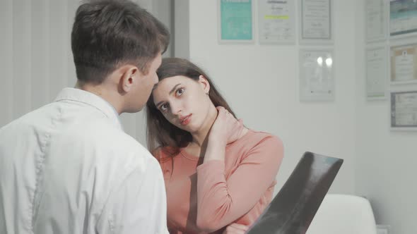 Woman with Neck Pain Talking to Her Doctor After Xray Scanning alt