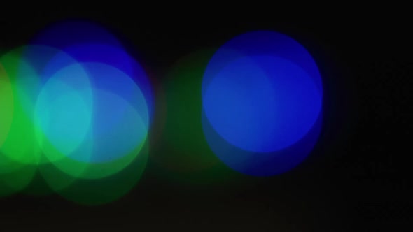 Multiple multicoloured lights flickering on black background alt