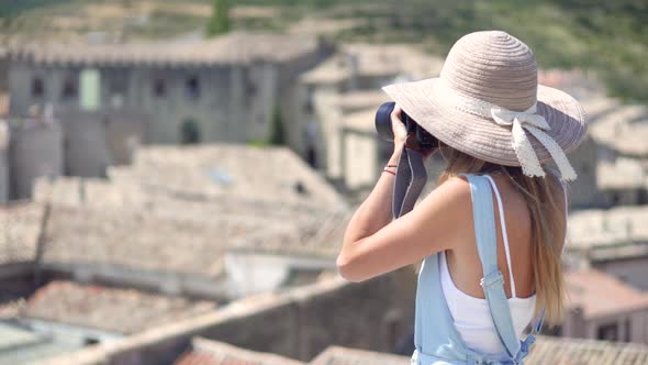 Faceless tourist woman taking photos alt
