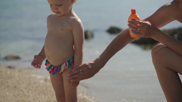 Mom Lubricates Her Two-year-old Daughter with Sunscreen
