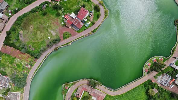 Right to left circular panning aerial view over the blue water and roads in small Mexican village alt