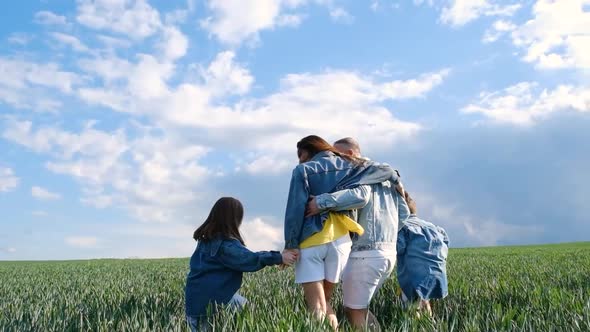 A Very Happy Family Hugs in the Middle of a Wheat Field alt