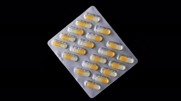 Blister Pack With Tablets Rotates On A Black Background.
