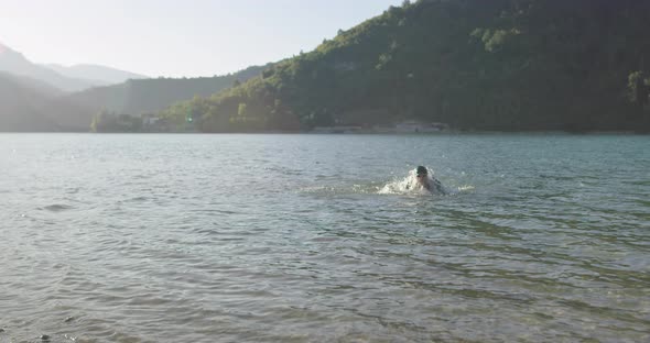 Determined Professional Triathlon Athlete in Wetsuit Start with Swimming Training for Ironman alt