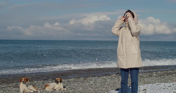 Happy Young Woman Standing By the Sea and Looking Through Binoculars