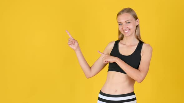 fit blonde girl in sportswear smiles and shows copy space