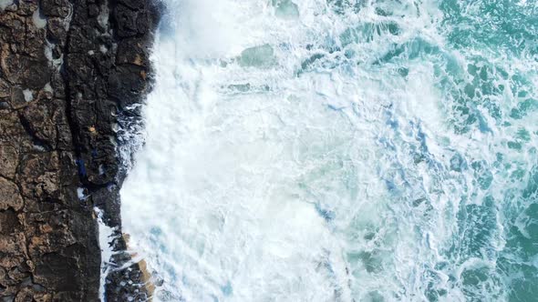 Aerial View of Waves Break on Rocks in a Blue Ocean Sea Waves on Beautiful Beach Bird's Eye View of alt