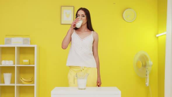 Young Woman Is Drinking Milk Looking At Camera alt