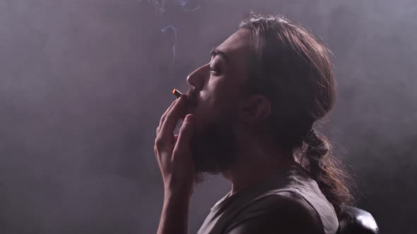 Hipsters Man Smokes a Homemade Cigarette Smokes alt