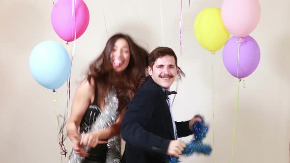 Slow motion of happy crazy couple enjoying dancing in photo booth alt