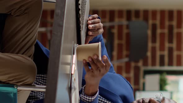 Vertical Video Businessman with Physical Chronic Disability Analyzing Report alt