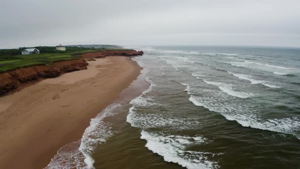 Aerial view of the waves approaching the empty Thunder Cove Beach on a grey, cloudy day. alt