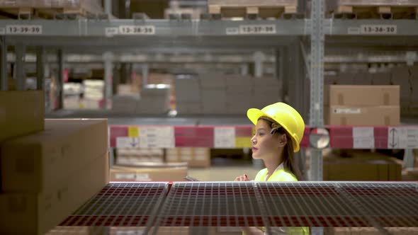 Asian woman warehouse worker checks stock and inventory with digital tablet computer alt