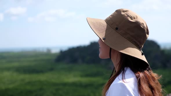 A woman looking at mangrove forest and sea