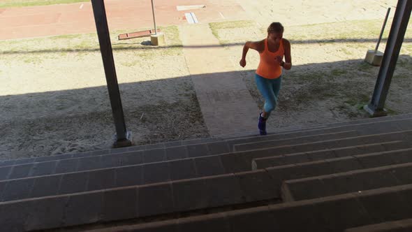 Front view of Caucasian female athlete exercising on steps at sports venue 4k alt