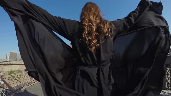 Woman in Black Long Flowing Dress Walks Across the Brooklyn Bridge in New York