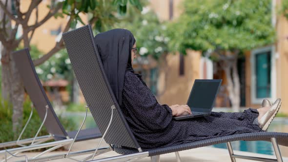 good looking Muslim women sitting outside working according to the slogan work form home