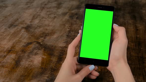 Woman Holding Black Smartphone with Blank Green Screen - Mockup Concept