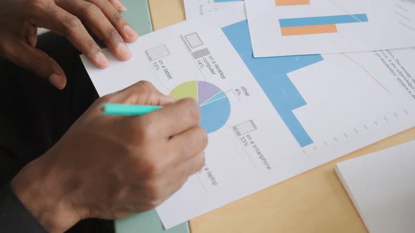 Group of Unrecognizable Business People Analyze Statistics Graphs and Diagrams