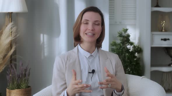 Young beautiful girl, blogger, vlogger, influencer, sitting at home, talking, looking at the camera alt