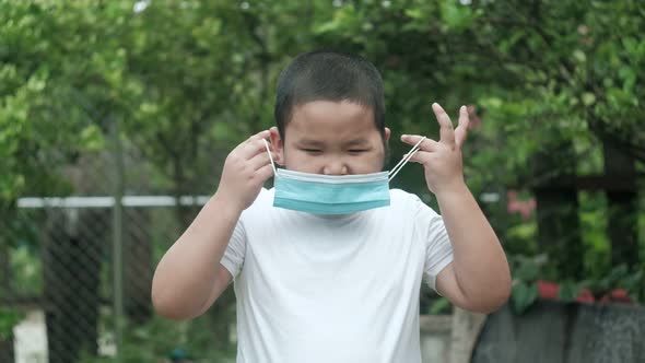 Asian boy putting on face mask against for corona virus prevention