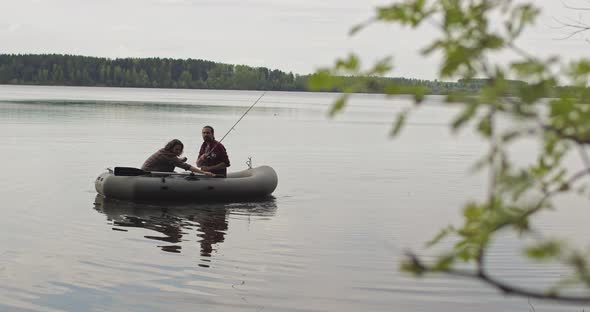 Young Fishermen on an Inflatable Boat on the Lake are Fishing