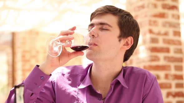 Young man drink wine in cafe