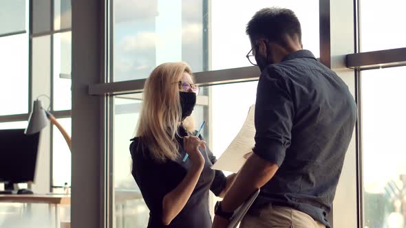 Two Colleagues Talking In Face Mask Office On Covid19 Coronavirus Pandemic Quarantine Lockdown. alt
