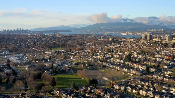 Rows Of Houses In Suburban Area In Burnaby With Vancouver Harbour And Skyline In Distance. wide aeri alt