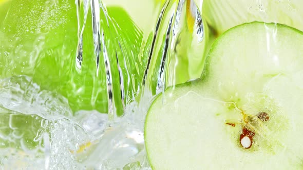 Super Slow Motion Shot of Pouring Water on Apple Slices and Ice Cubes in Glass at 1000 Fps alt