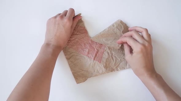 Female Hands are Tearing Paper with a Drawn Red Heart alt