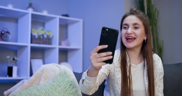 Smiling Vlogger Girl Looking at Mobile Make Video Call Shooting Vlog Taking Selfie alt