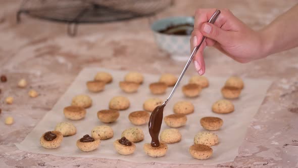 Woman Holding Spoon of Melted Dark Chocolate in Baking Cookies